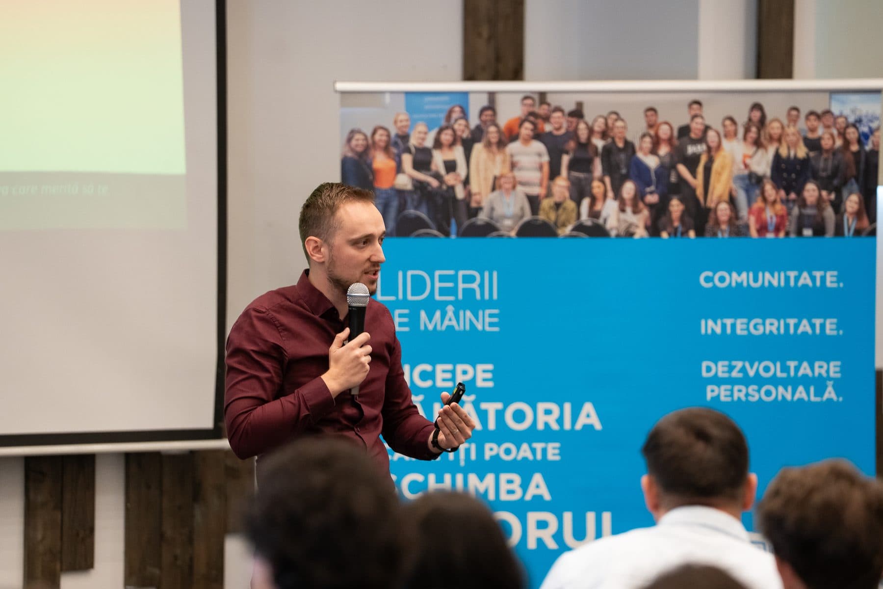 Vorbitor cu microfon lângă bannerul LDM cu valorile Comunitate, Integritate, Dezvoltare personală