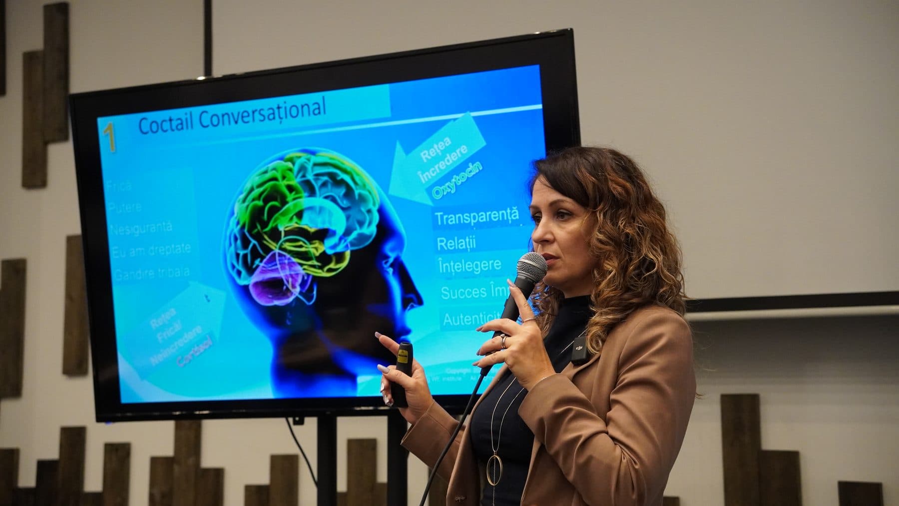 Vorbitoare cu microfon prezintă un slide cu creierul uman despre comunicare, la întâlnirea de marți